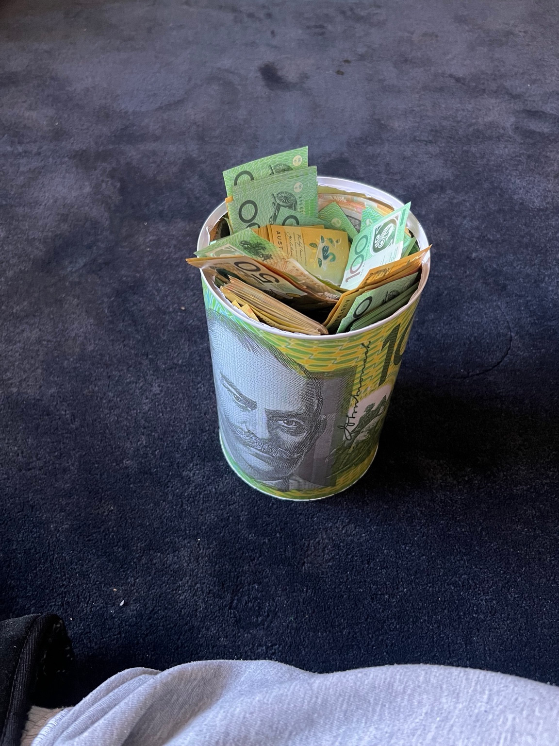 A photo of Lucas’s savings tin containing Australian banknotes.